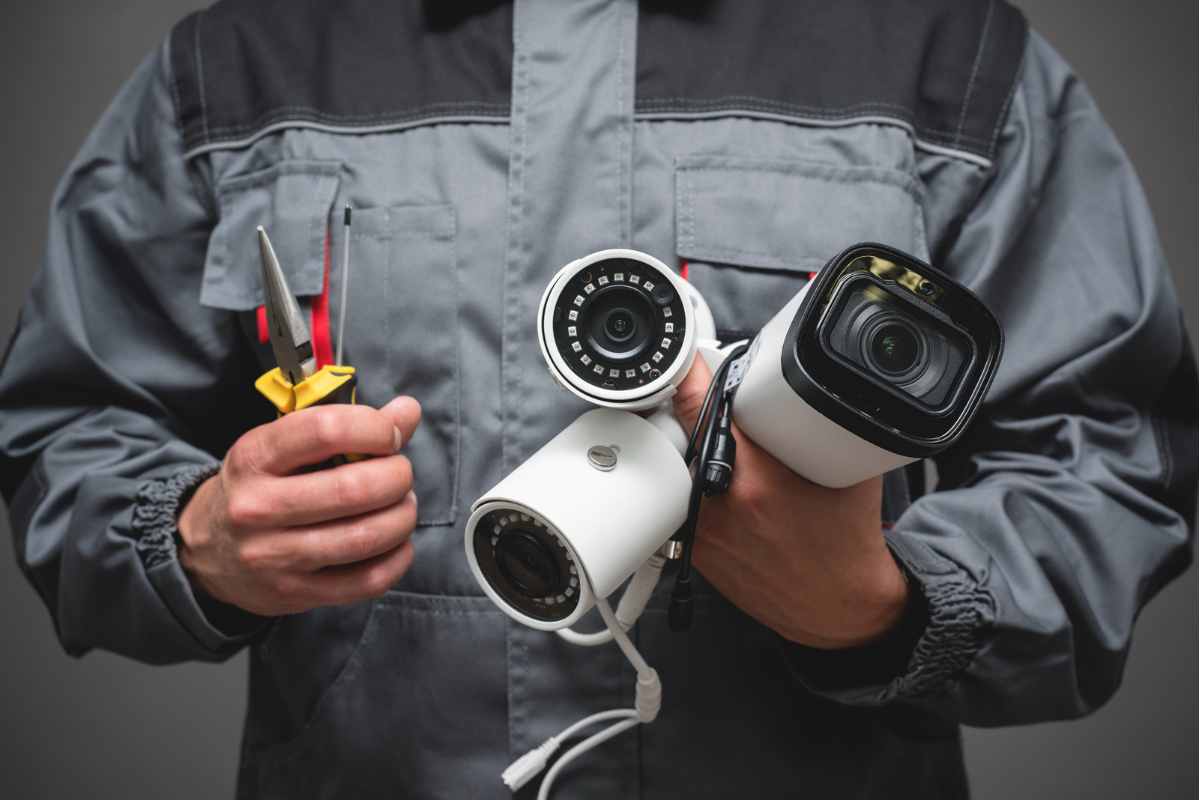 A Man holding some Smart home cameras and tools